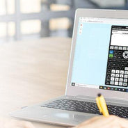 Person using a laptop displaying a Texas Instruments calculator app, education technology setting.