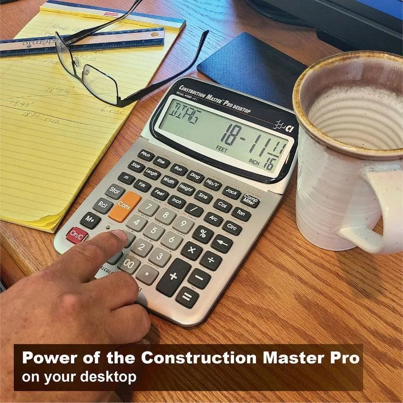 Construction Master Pro desktop calculator on an office desk with coffee, notepad, and glasses