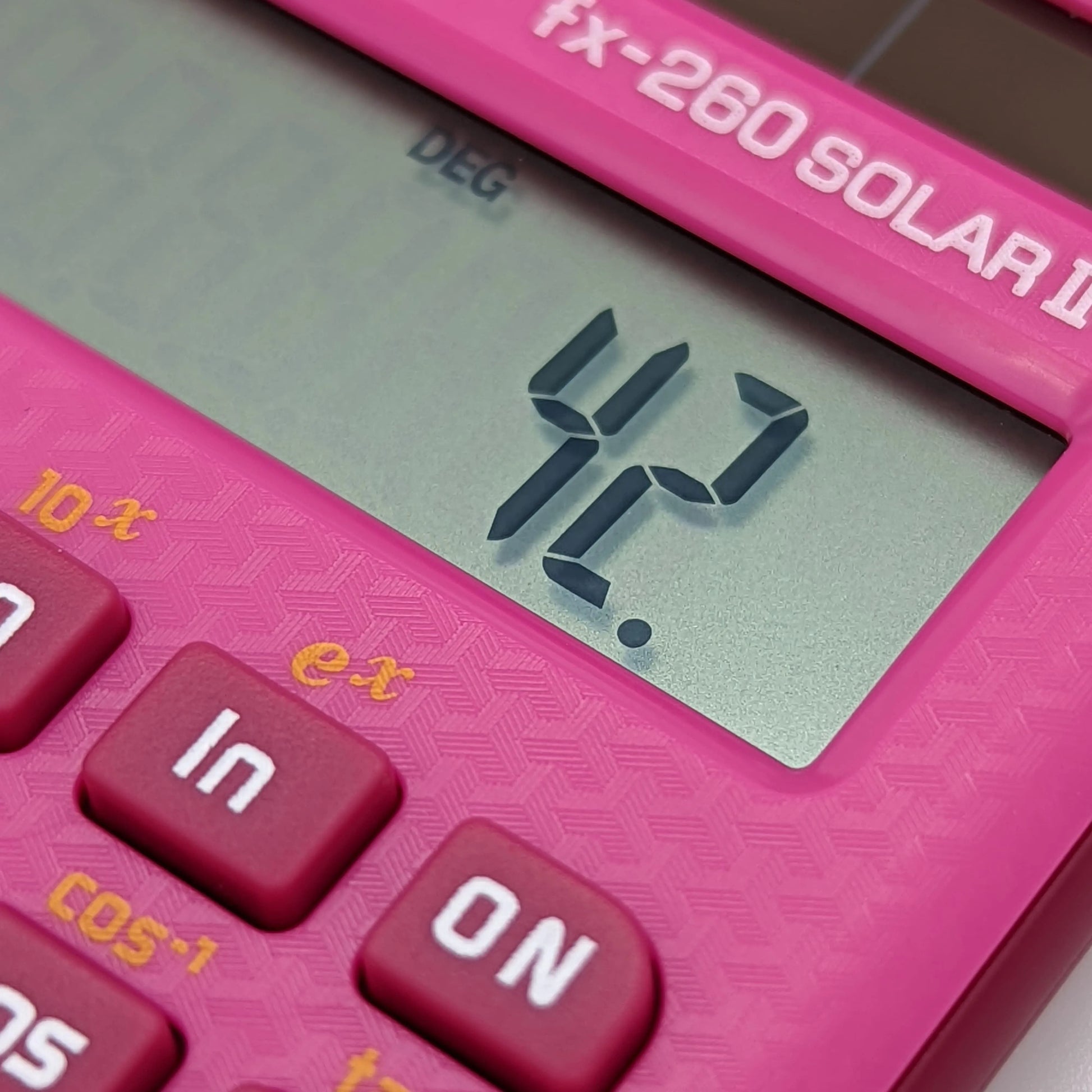 Close-up of pink Casio FX-260 Solar II calculator displaying 42, Underwood Distributing Co.