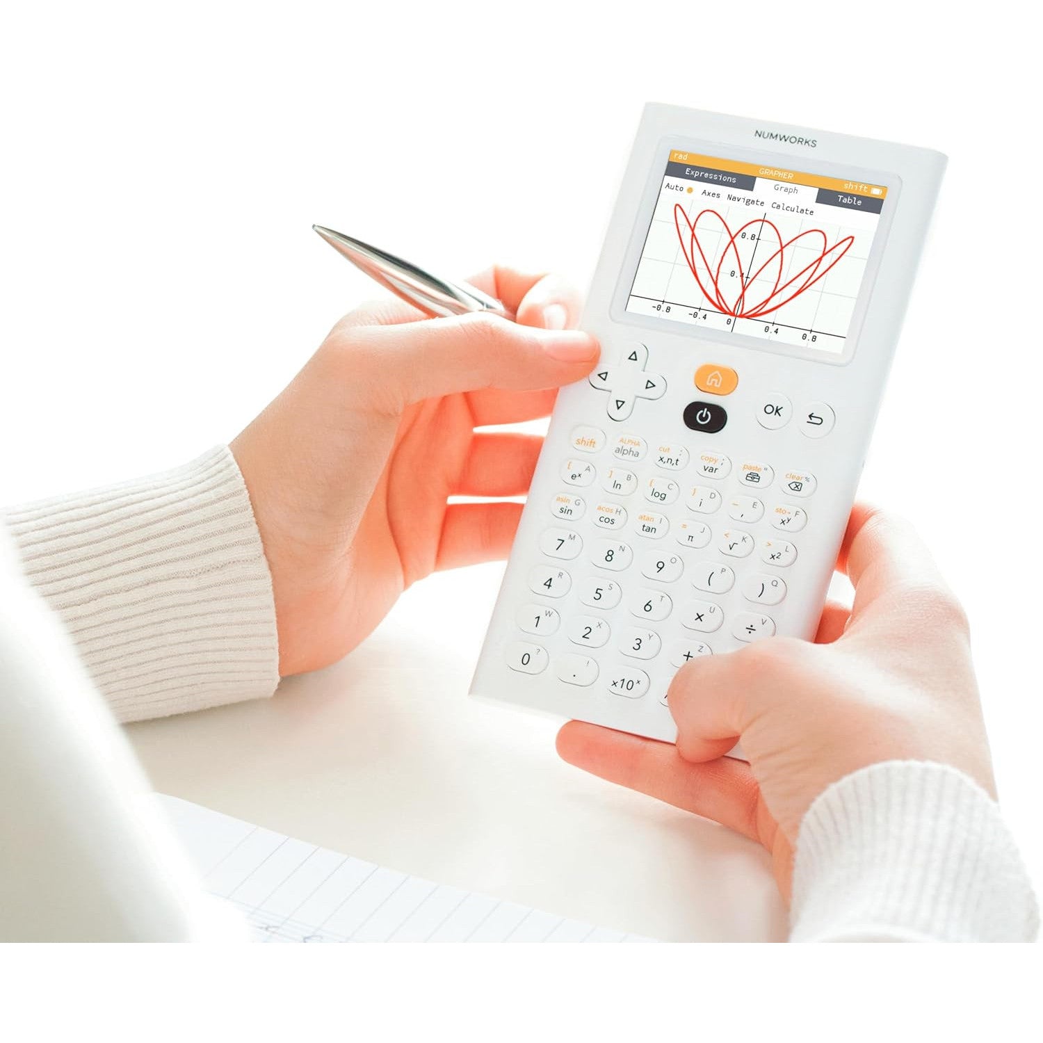 Person using NumWorks graphing calculator, displaying graph, from Underwood Distributing Co.