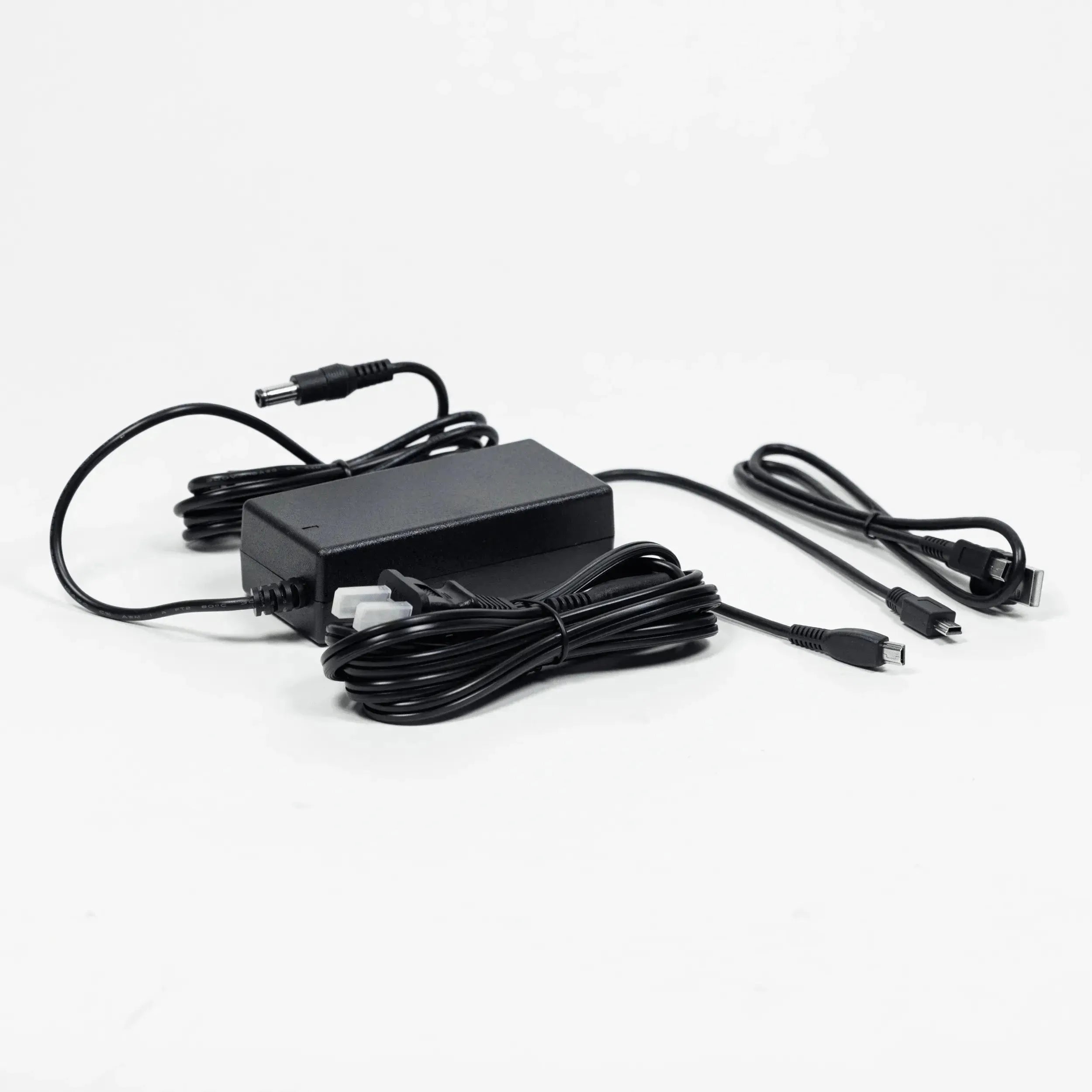Texas Instruments black power adapter and charging cables set on white background