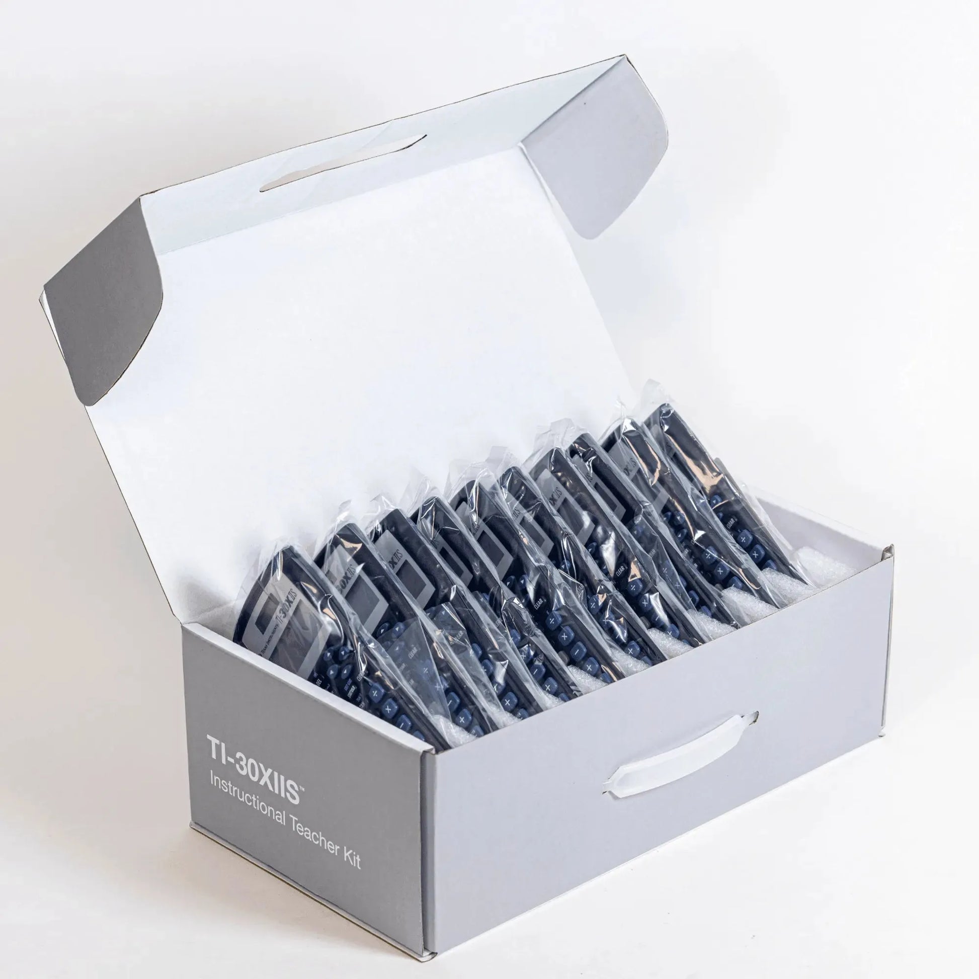 Box of 30 TI-30XIIS scientific calculators in individual plastic sleeves, Underwood Distributing Co.