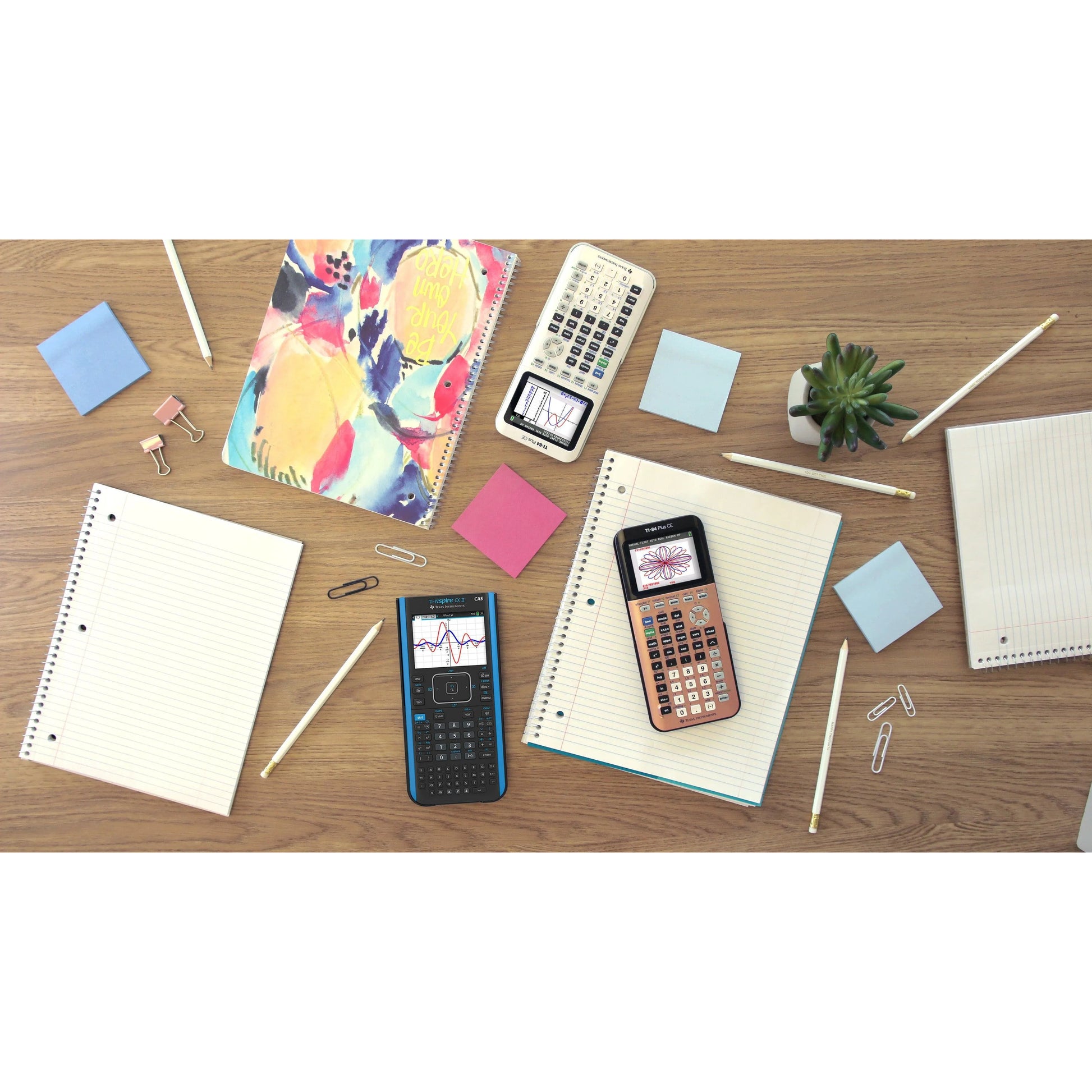 Texas Instruments TI-Nspire CX II CAS graphing calculator on desk with notebooks and school supplies.