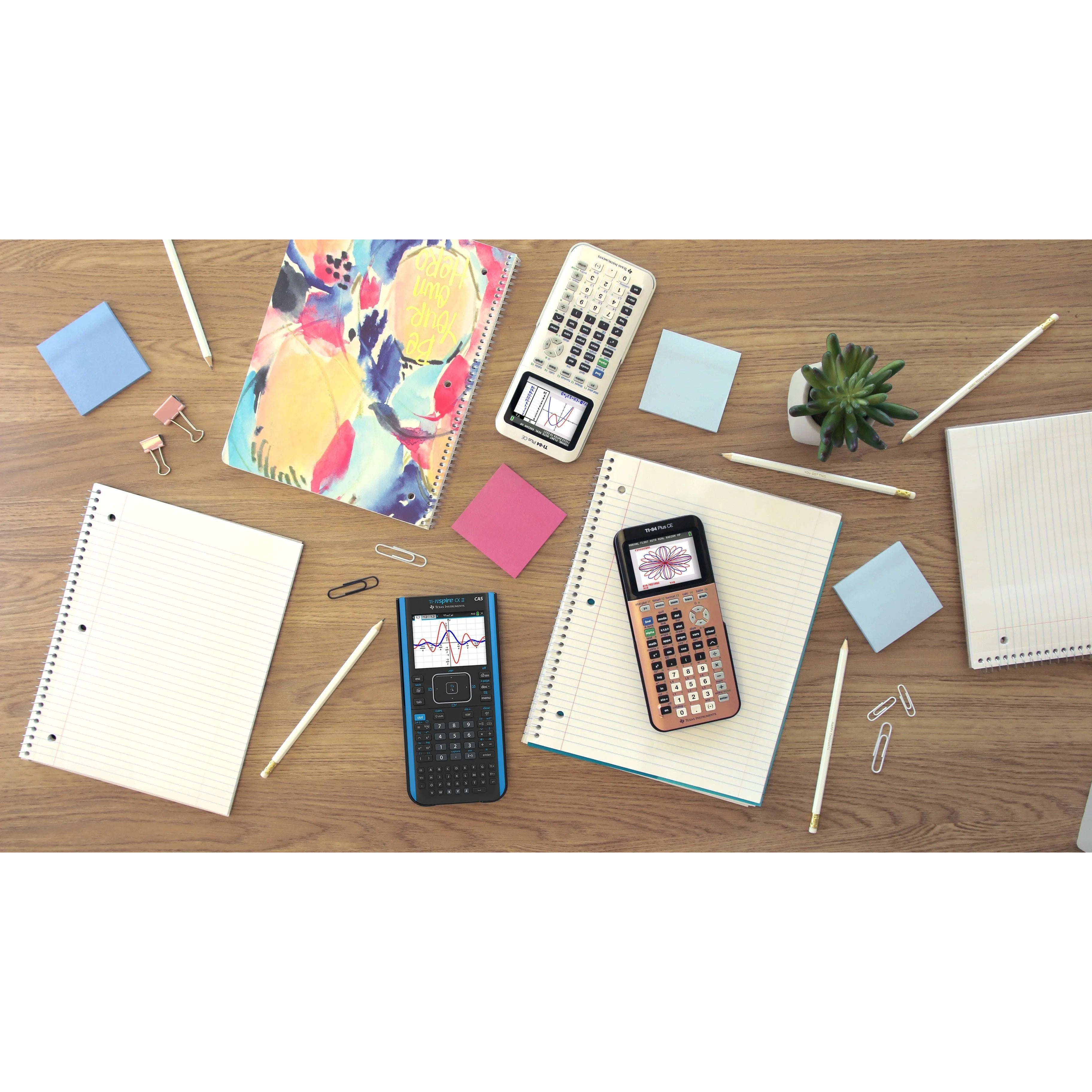 Texas Instruments TI-Nspire CX II CAS graphing calculator on desk with notebooks and school supplies.