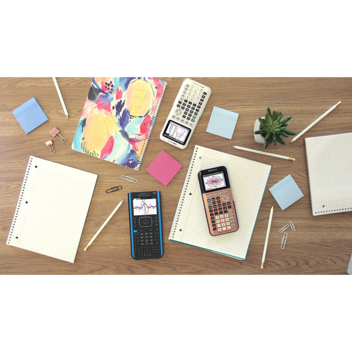 Texas Instruments TI-Nspire CX II CAS graphing calculator on desk with notebooks and school supplies.