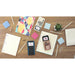 Texas Instruments TI-Nspire CX II CAS graphing calculator on desk with notebooks and school supplies.