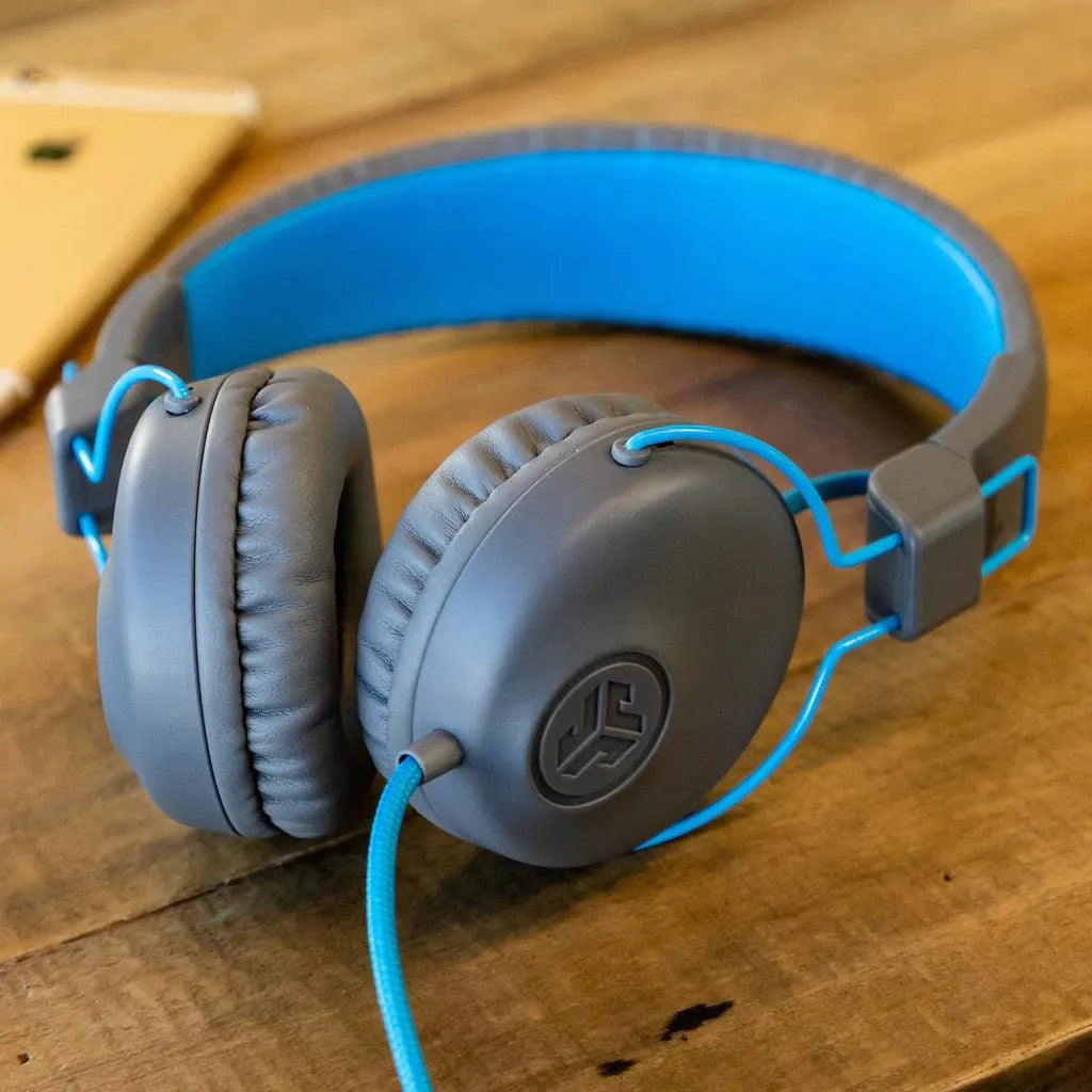 JLab Studio gray and blue wired headset on wood table, available at Underwood Distributing Co.